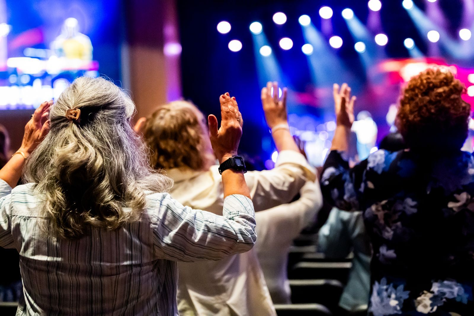 Church members lifting their hands in praise during a worship service, as on church cruises
