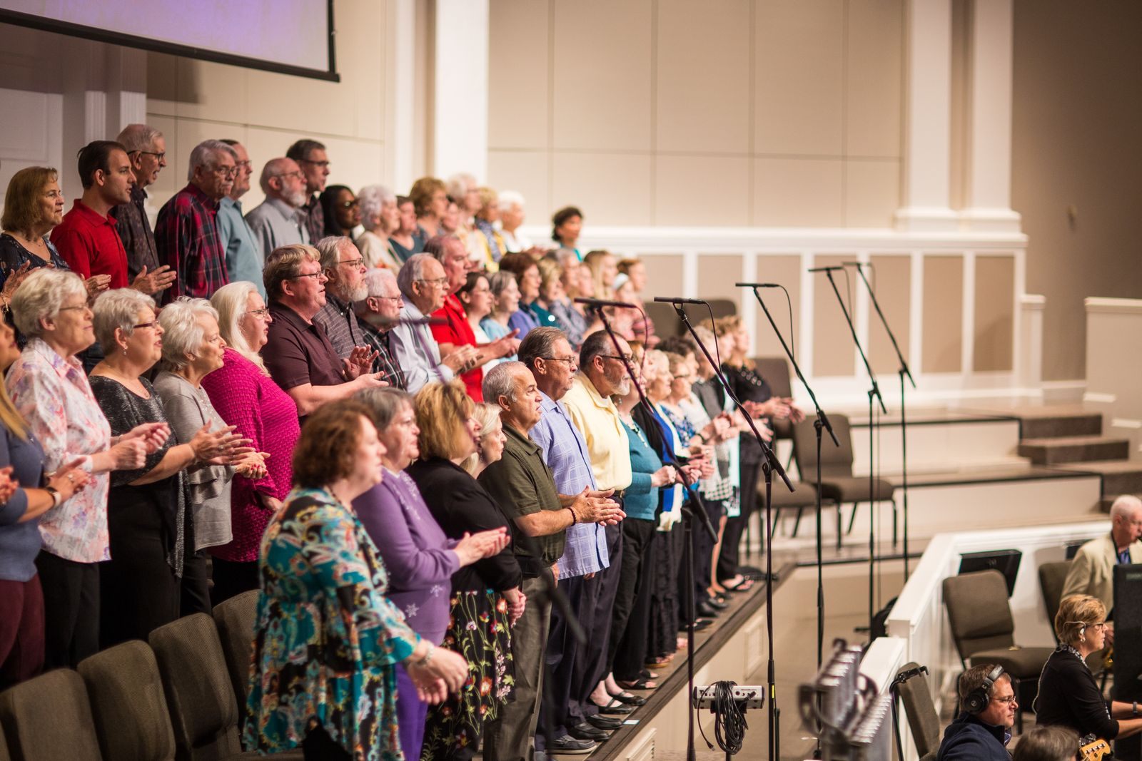 Church choir singing together at the front of a sanctuary