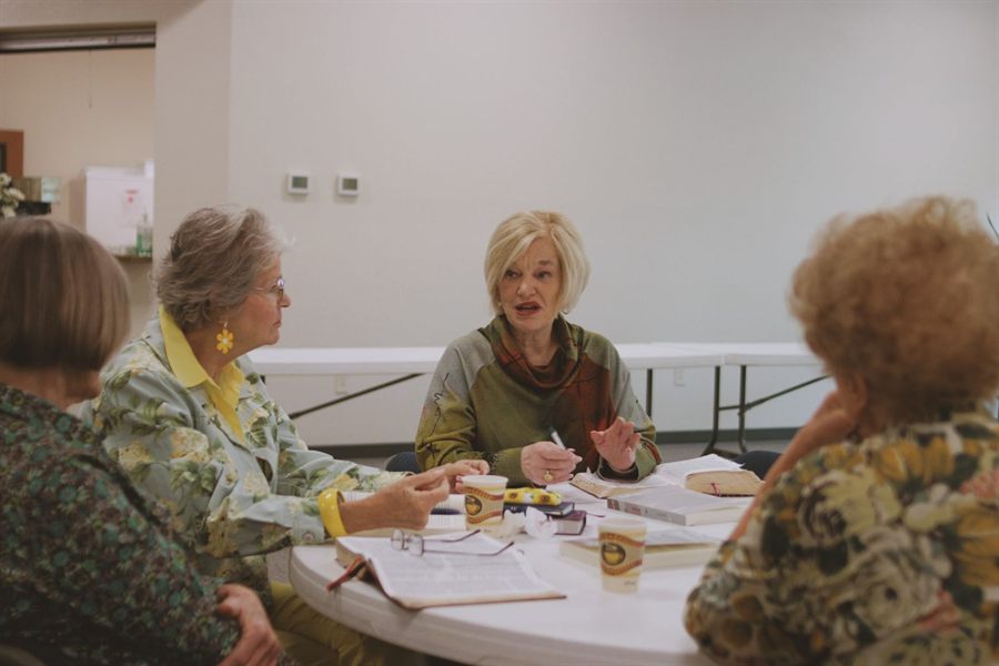 Women of different ages gathered around a table for a Bible study