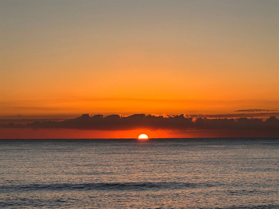 Orange sunrise over a calm ocean horizon