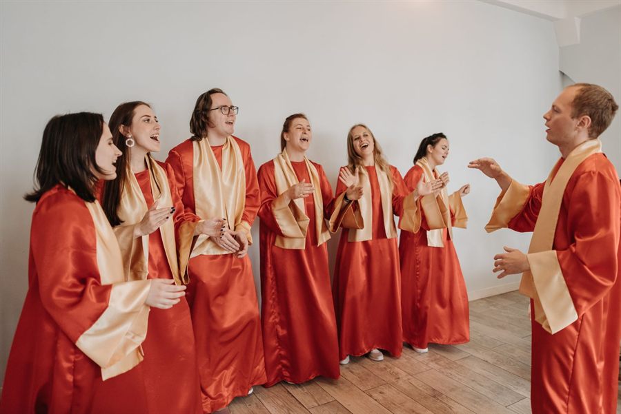 Choir in red robes singing joyfully